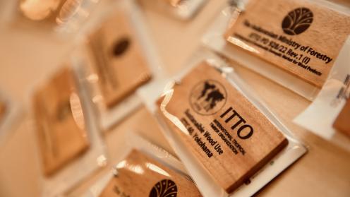 Wooden name tags featuring ITTO and partner logos, displayed at the ITTC60 session.