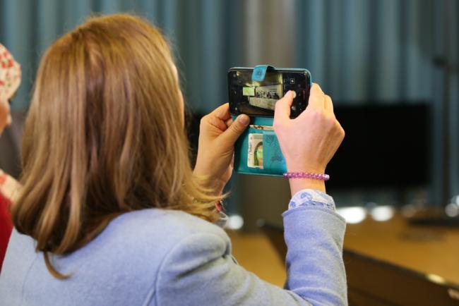 Delegates take photos of information presented