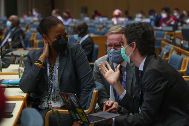 Delegates consult during the session