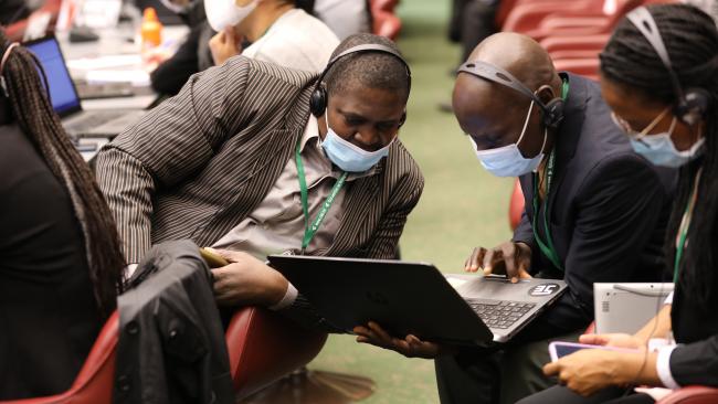 Delegates conferring during a break in negotiations