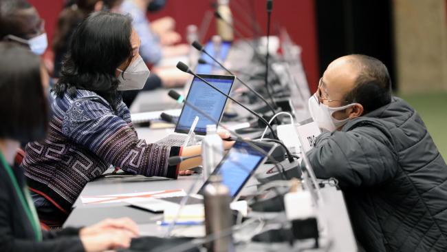 Participants conferring during a break in negotiations