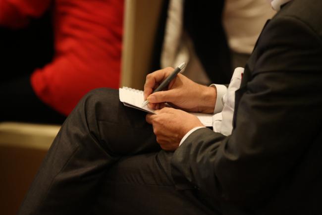 A delegate takes notes during a contact group