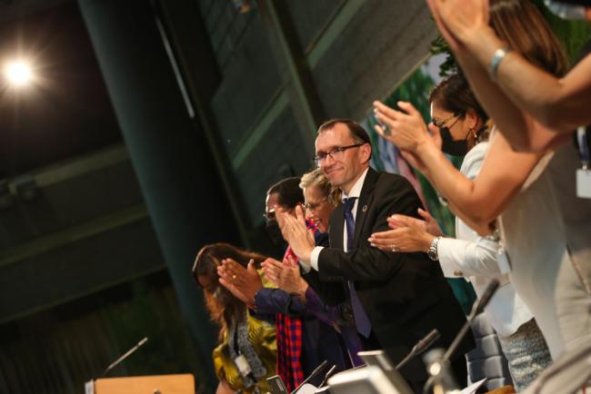 The dais gives a standing ovation in response to the global plastics treaty