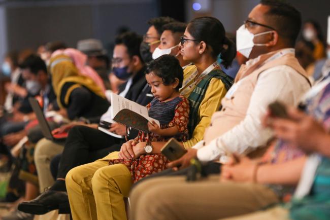 A young participant checks the programme for the day