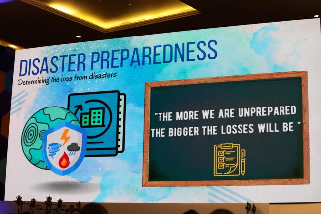A slide during the opening ceremony reminds delegates that 'the more we are unprepared, the bigger the losses will be'.