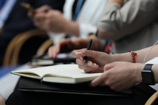 Delegates take notes during the session