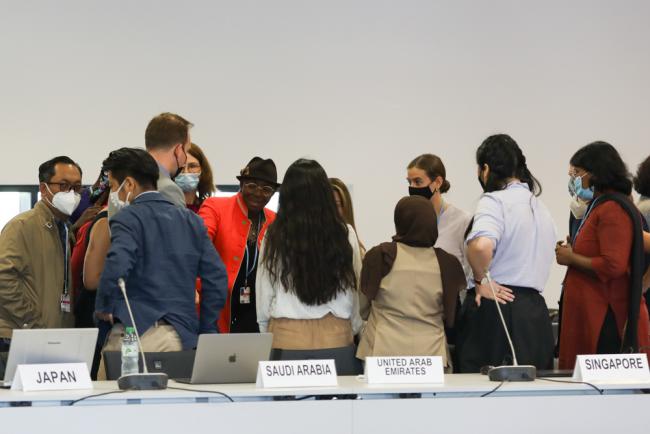 Delegates huddle during the informal consultations on matters relating to the Glasgow work programme on Action for Climate Empowerment (ACE)