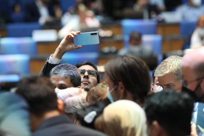 A delegate takes a photo of the huddle