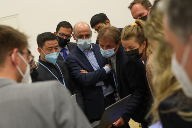 Delegates huddle during the informal consultations on arrangements for intergovernmental meetings (AIM)