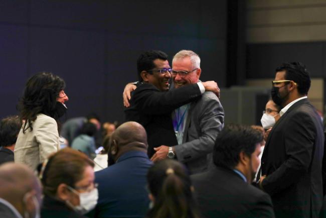 Delegates embrace as the meeting in Bonn takes place for the first time in three years