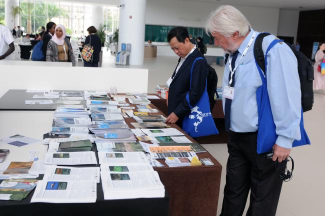 Delegates check the CITES publications available at the venue