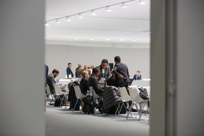 Delegates huddle before the informal, parties-only consultation on loss and damage begin.