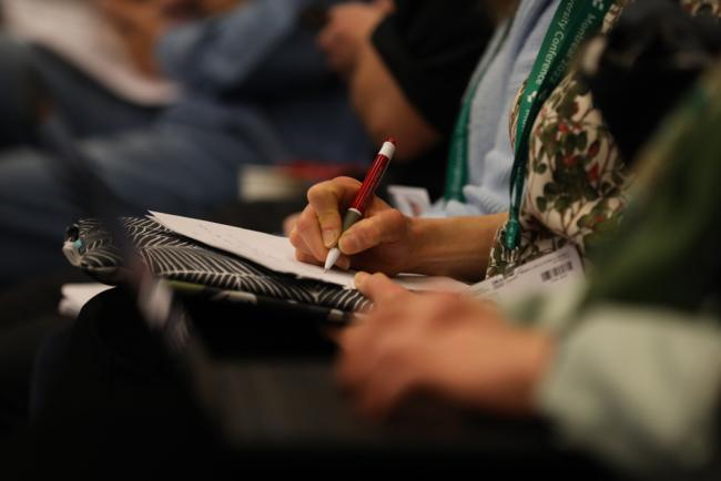 Delegates take notes during the session