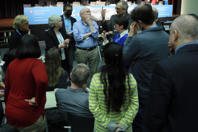 Authors consulting informally in a huddle to