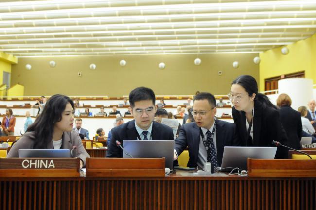 The Chinese delegation discuss one of their statements for the day