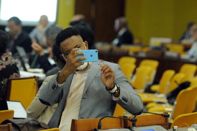 A delegates takes a photo of the presentation