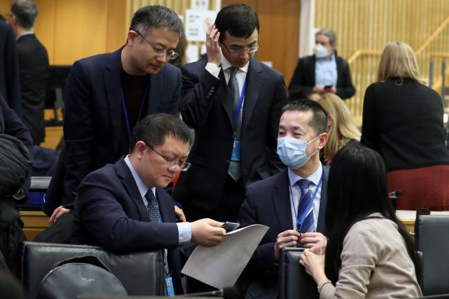 Delegates from China conferring during a break in negotiations