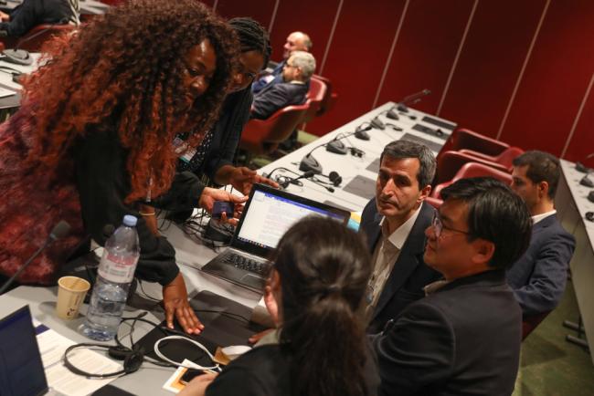 Delegates from South Africa, Lesotho, Iran and China huddle during the Technical Assistance and Financial Resources Contact Group