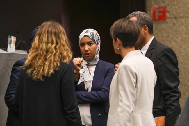 Delegates speak informally between sessions