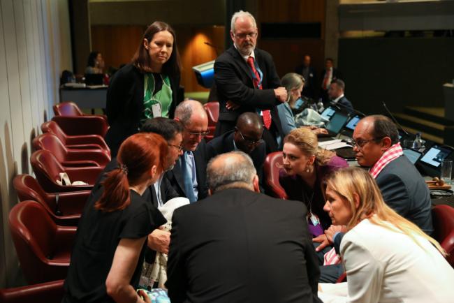 Members of the Rotterdam Convention bureau consult on the podium as they determine a way forward for the contact group to discuss the proposed amendment to the Convention