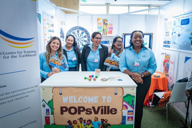 Group of participants smiling at a booth at BRS COPs PCB Fair 
