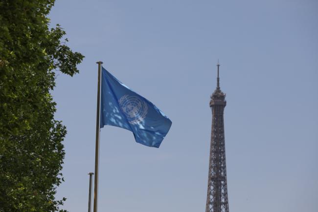 On the penultimate day of INC-2, the UN flag flies outside UNESCO Headquarters as negotiations continue in contact groups