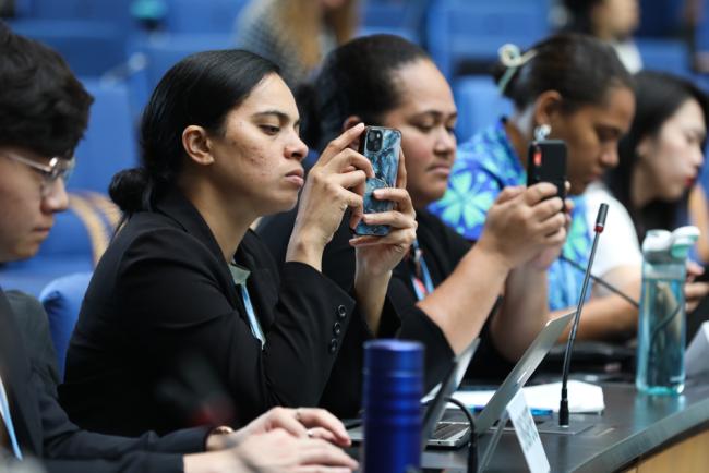 Delegates take photos of the interventions