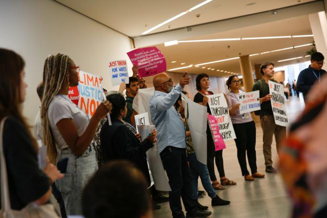 Members of civil society demonstrate in the corridor calling for a just transition for workers and communities