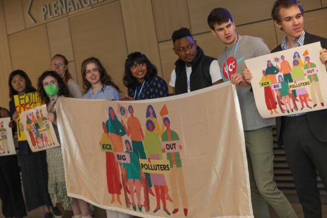 Members of civil society demonstrate for greater transparency within the process, saying 'people in, polluters out'