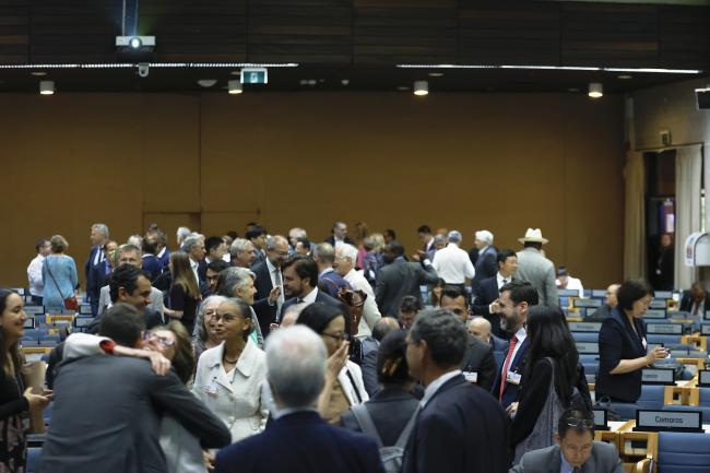 Delegates consulting informally before the opening plenary