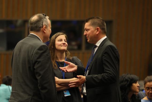 Delegates speak informally between sessions