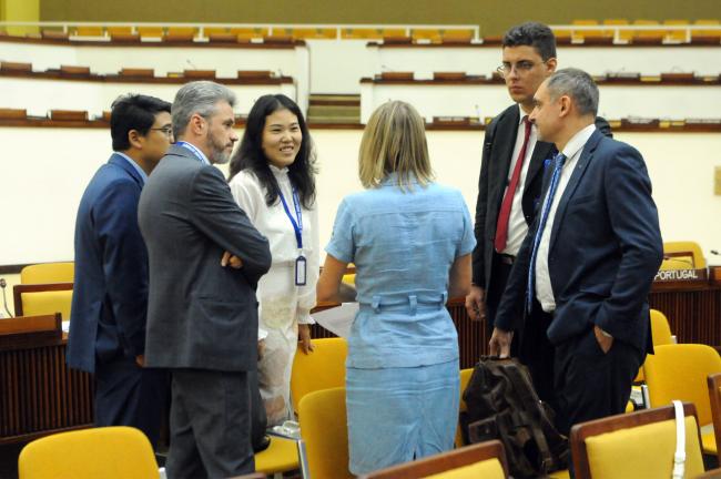 Delegates from China and the Russian Federation confer at the end of the meeting