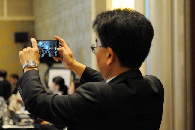 A delegate takes a photo of participants