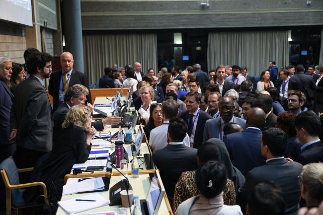 Delegates consulting informally with INC Chair Gustavo Meza-Cuadra, Peru