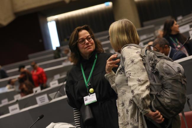 Delegates speak informally before the start of plenary