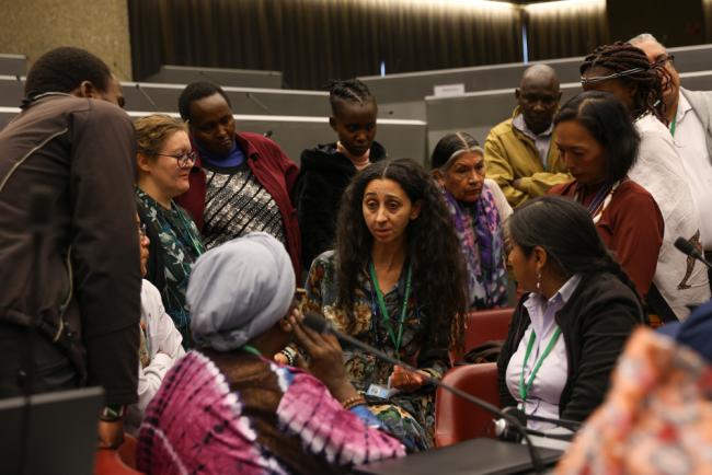 Representatives of different Indigenous Peoples and local communities huddle 