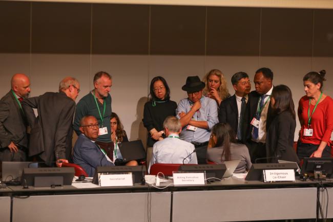 The Working Group Co-Chairs consult with the CBD Secretariat as debate rises around the language of Indigenous Peoples and local communities continues in the afternoon plenary