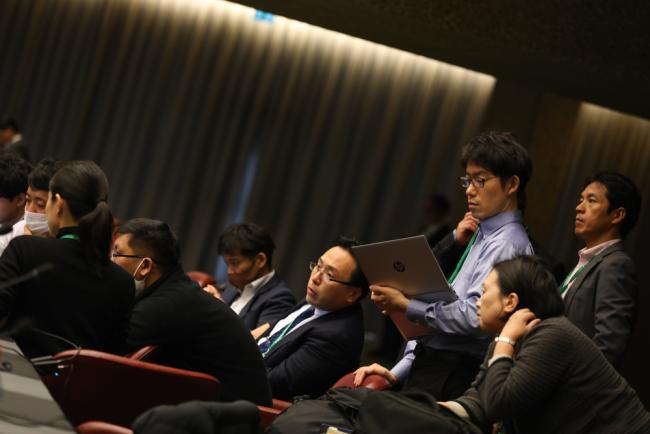 Delegates review the negotiating text at the start of the day