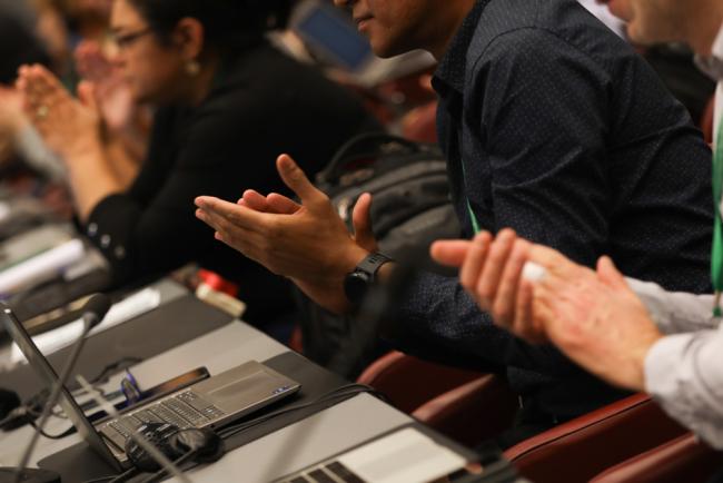 Delegates applaud the closure of the meeting