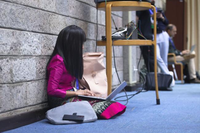 Taking notes at the back of the room 
