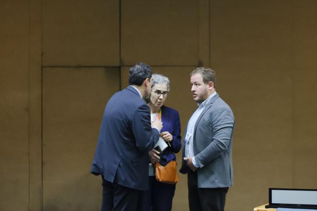 Delegates consult informally at the back of the room