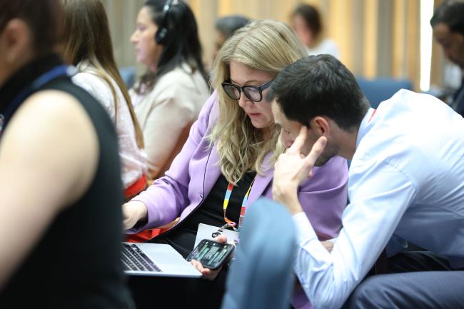 Delegates consult informally during the plenary 