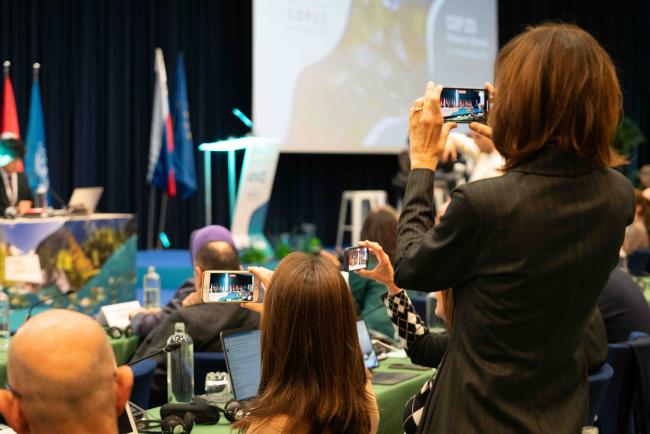 Delegations taking photographs during the student speaches