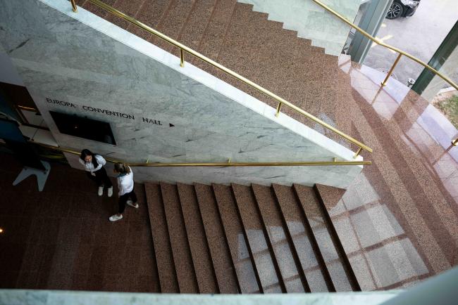 staircase up to the plenary floor, with staff scanning people in for safety reasons