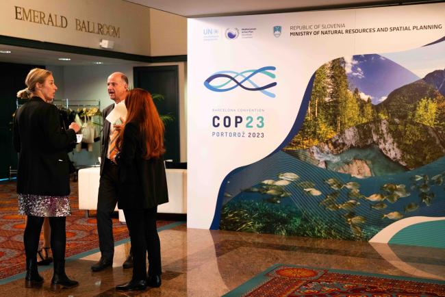 People speaking next to the COP 23 sign