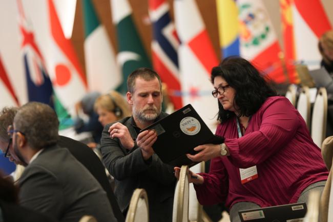 Delegates from the UK consult during the session