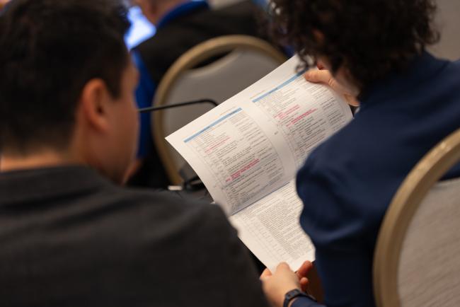 Delegates page through the long list of agenda items to be discussed throughout the day