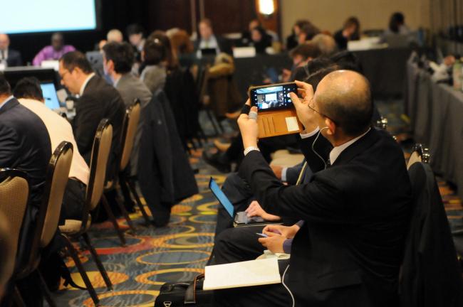 Wataru Suzuki, Ministry of the Environment, Japan, takes a photo of one of the presentations