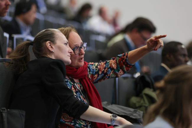 Delegates discuss the text projected on the screen