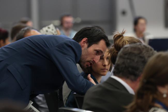 Delegates consult during the session